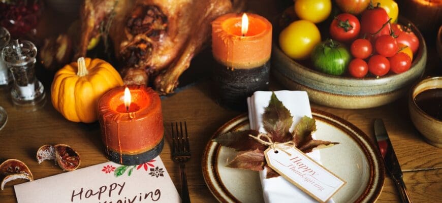 Dining room table set for thanksgiving with food, table set and candles.