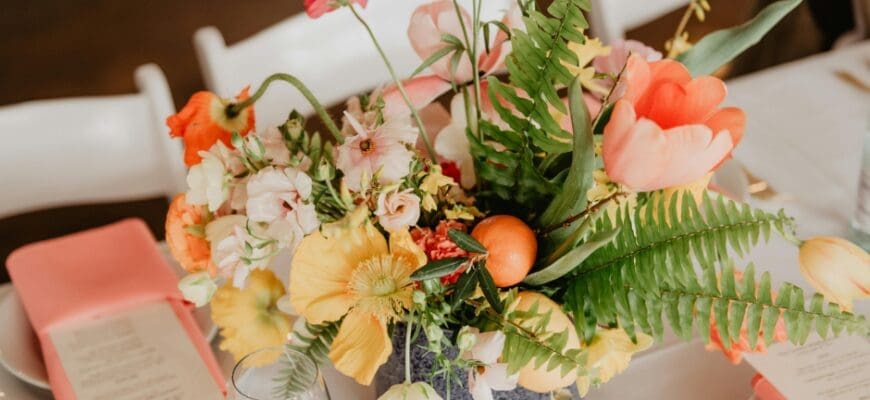 A Table Setting with Plates, Wine Glasses, Napkins, and a Large Flower Bouquet